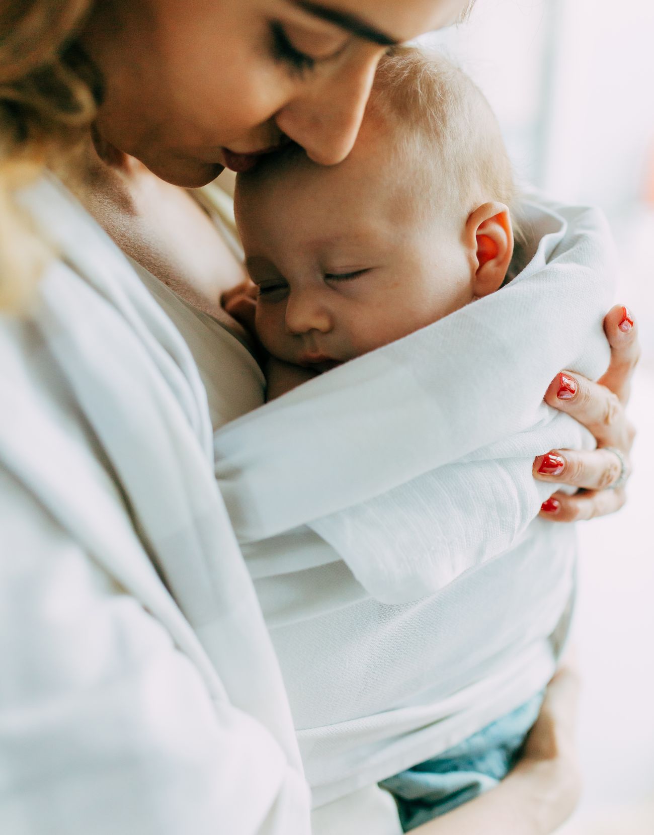 a mother cuddling her newborn baby