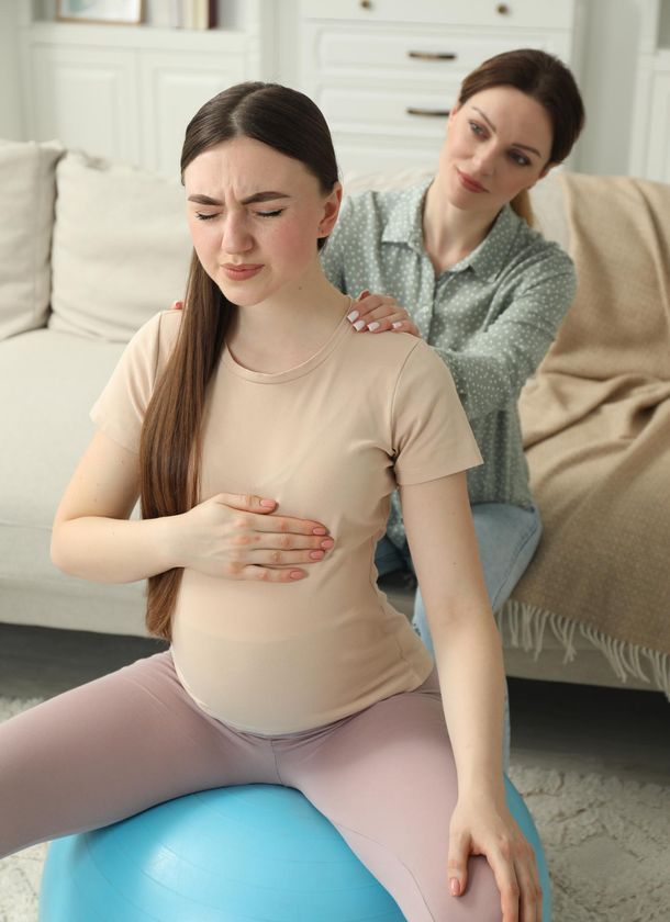 a woman giving birth on a yoga ball