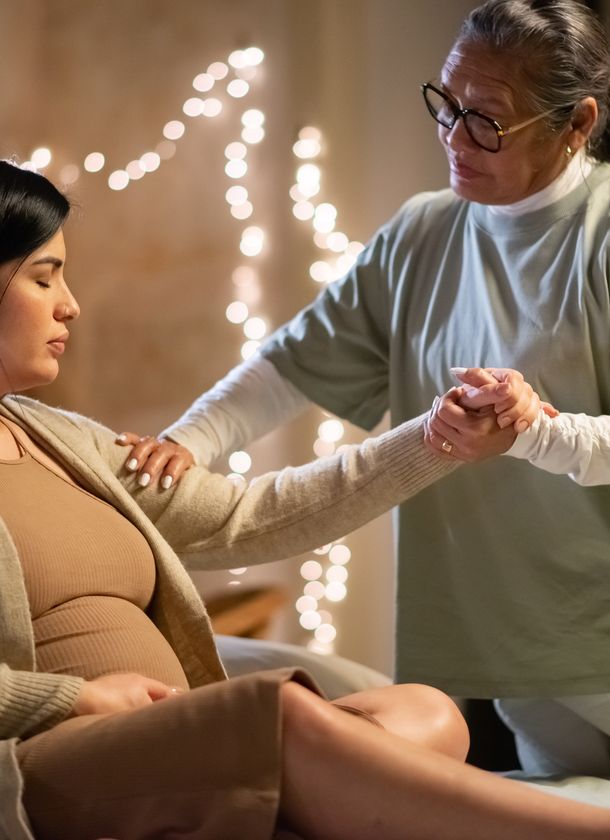 a doula helping a pregnant mother up