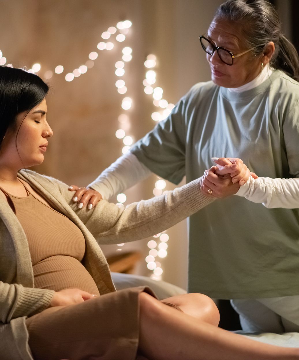 a doula helping a pregnant mother up