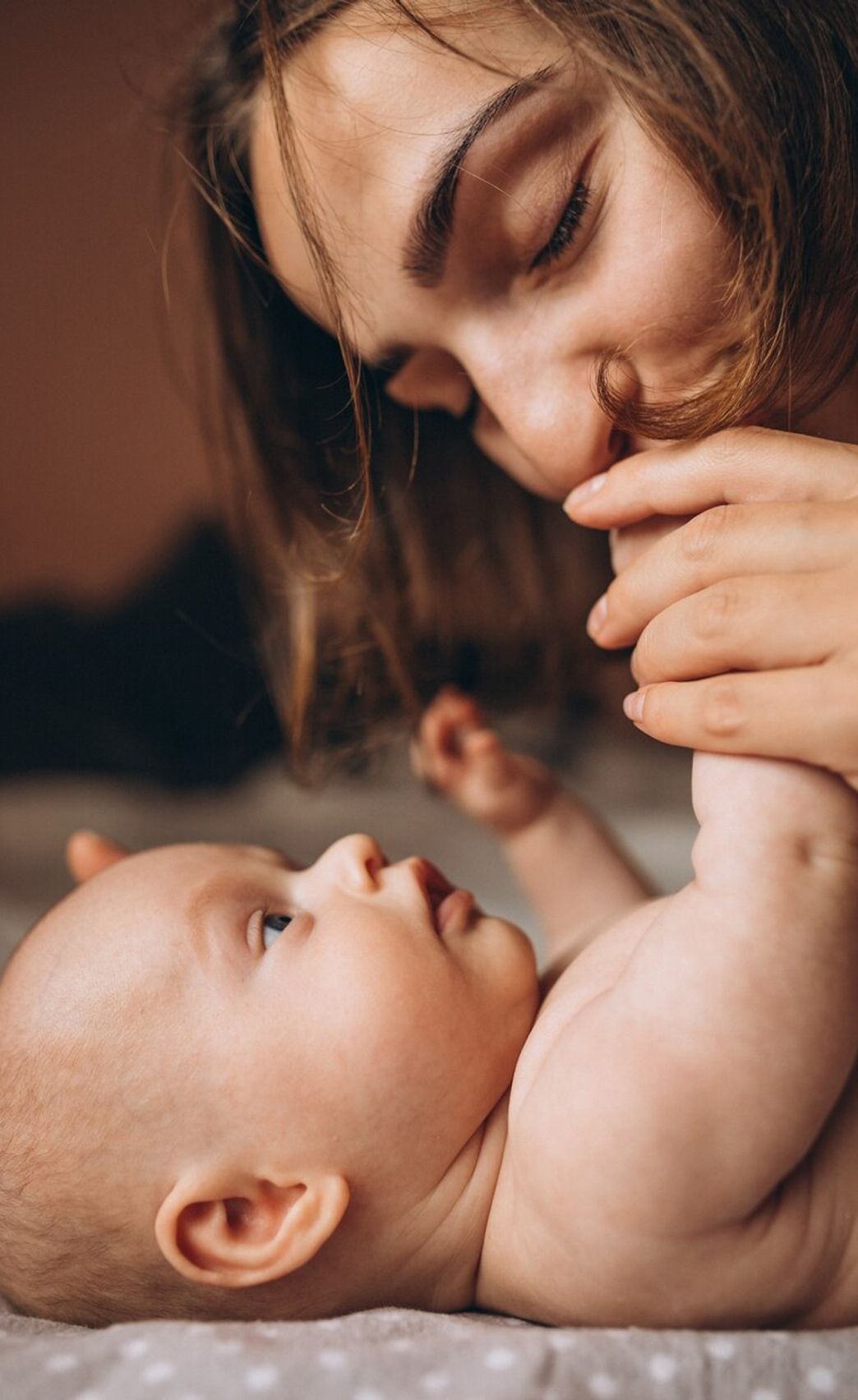 a mother kissing her baby's hand